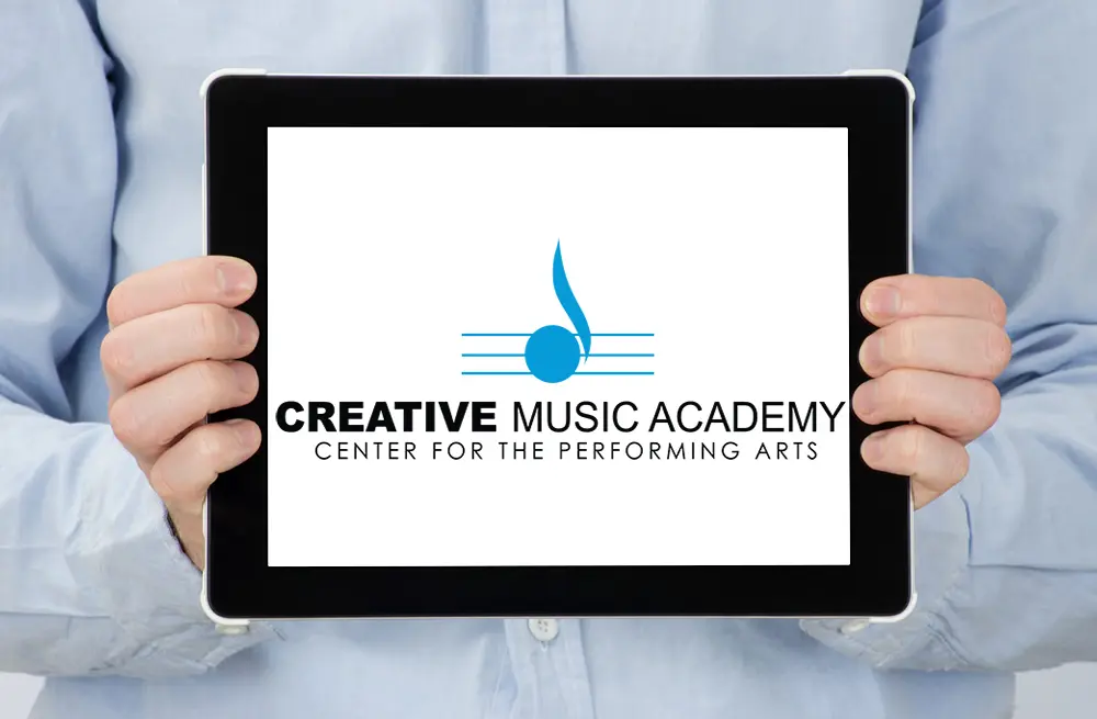 Tablet Shows the Creative Music Academy Logo with a Blue Musical Note and the Text 'center for the Performing Arts' Held by a Person in a Light Blue Shirt Tablet Shows the Creative Music Academy Logo with a Blue Musical Note and the Text 'center for the Performing Arts' Held by a Person in a Light Blue Shirt