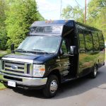 Black Shuttle Van Parked on a Tree-lined Street, Reflecting Greenery in Its Windows; Virginia License Plate Visible at the Front. Black Shuttle Van Parked on a Tree-lined Street, Reflecting Greenery in Its Windows; Virginia License Plate Visible at the Front.