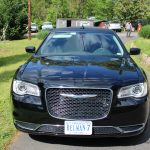 Front View of a Black Suv with Virginia Plate Belman-7 Parked on a Driveway; Trees and Lawn in Background. Front View of a Black Suv with Virginia Plate Belman-7 Parked on a Driveway; Trees and Lawn in Background.